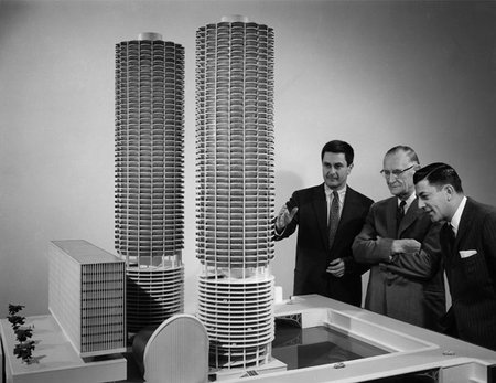 L'architecte Bertrand Goldberg (premier à gauche) devant la maquette de Marina City